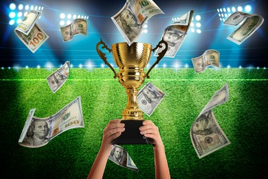 Image of Woman holding gold trophy cup in money rain at stadium, closeup