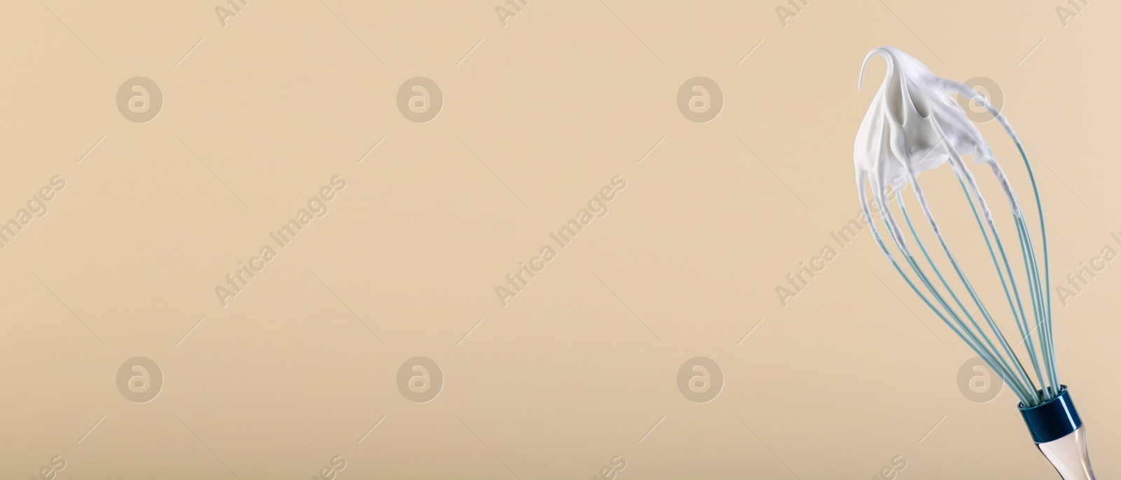 Image of Whisk with beaten cream on dark beige background, closeup. Banner design, space for text