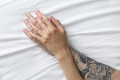 Photo of Lovely couple holding hands in bed, top view