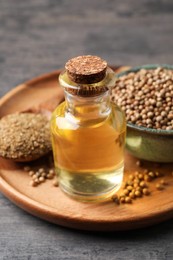 Coriander essential oil, seeds and powder on grey table