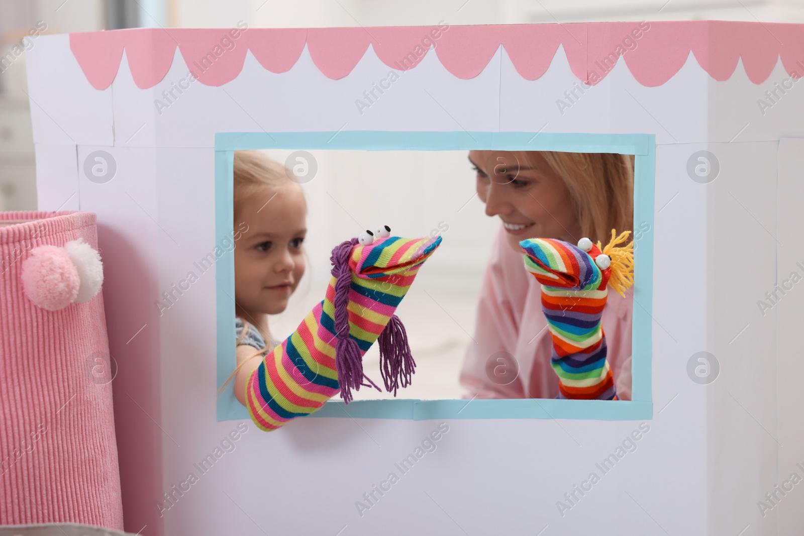 Photo of Mother and daughter performing show in puppet theatre at home