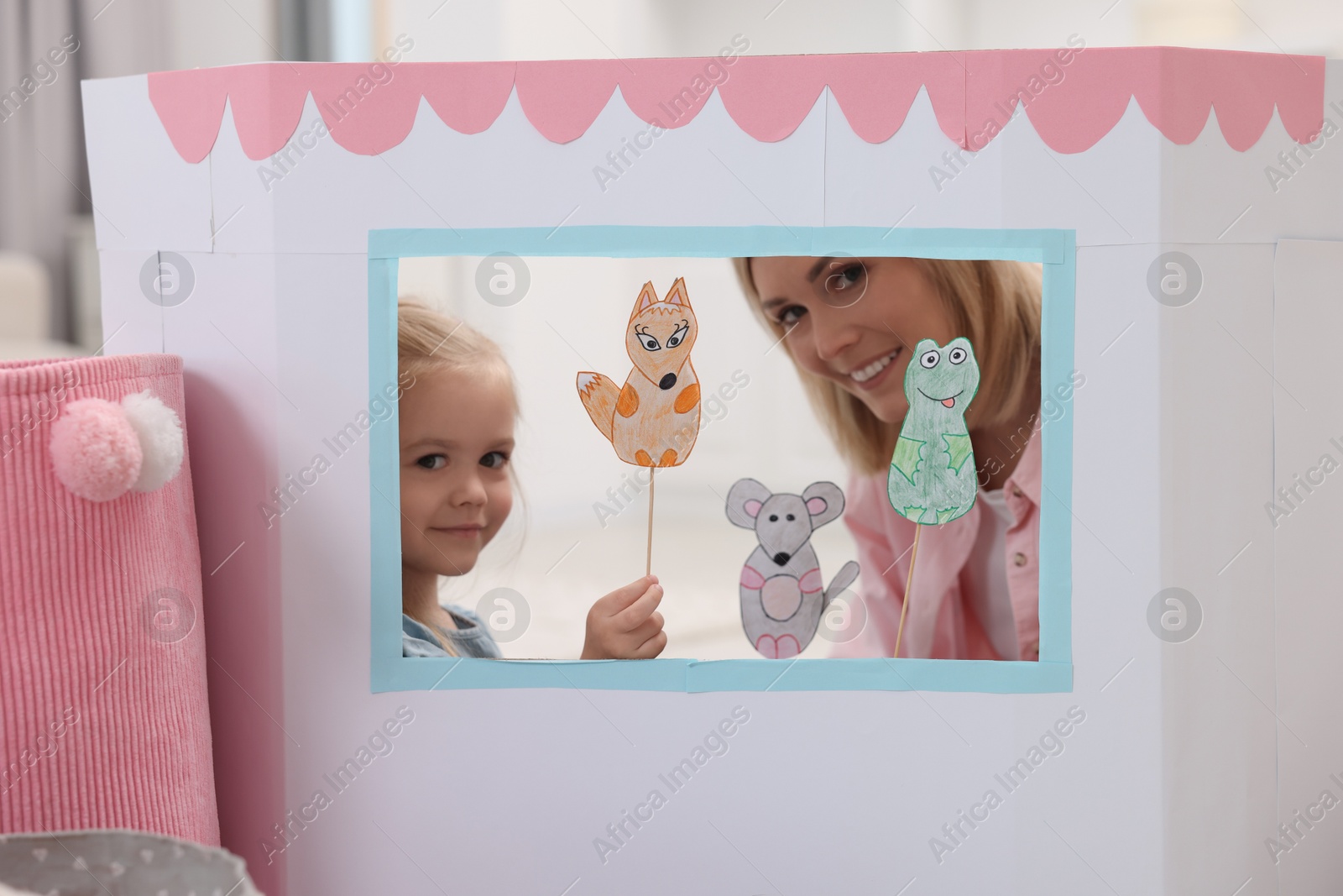 Photo of Mother and daughter performing show in puppet theatre at home