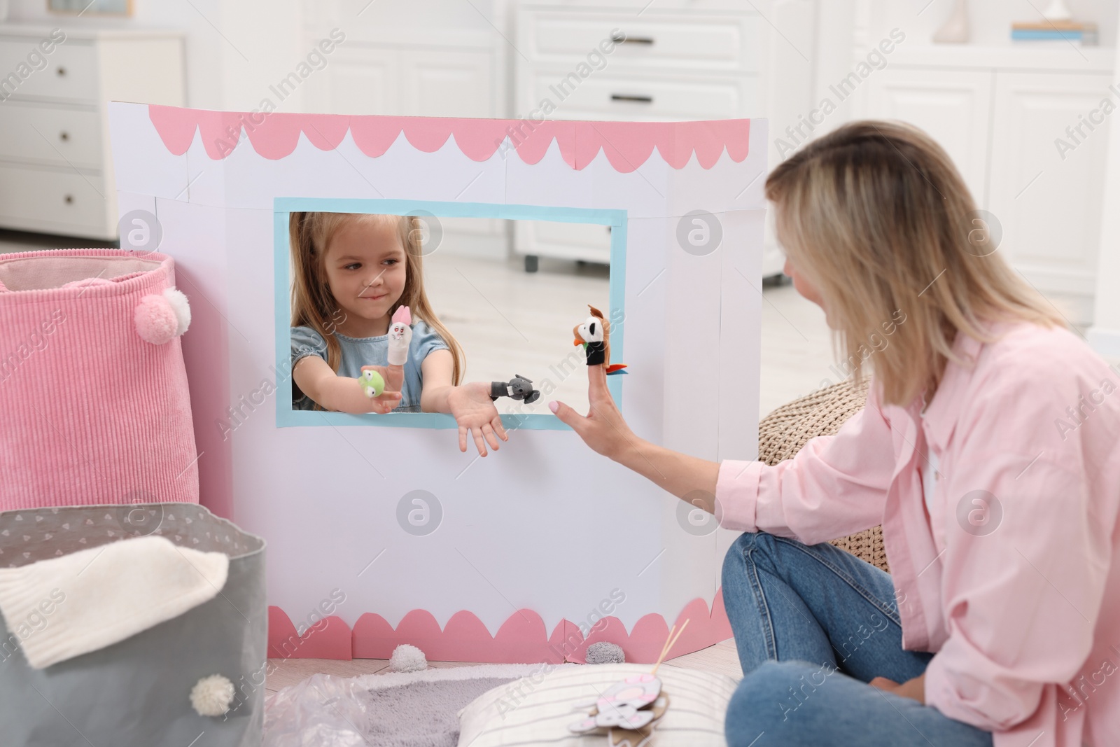 Photo of Puppet theatre. Mother and daughter performing show at home