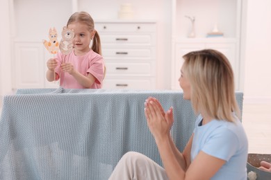 Photo of Puppet theatre. Girl performing show to her mother at home