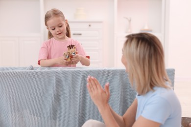 Puppet theatre. Girl performing show to her mother at home