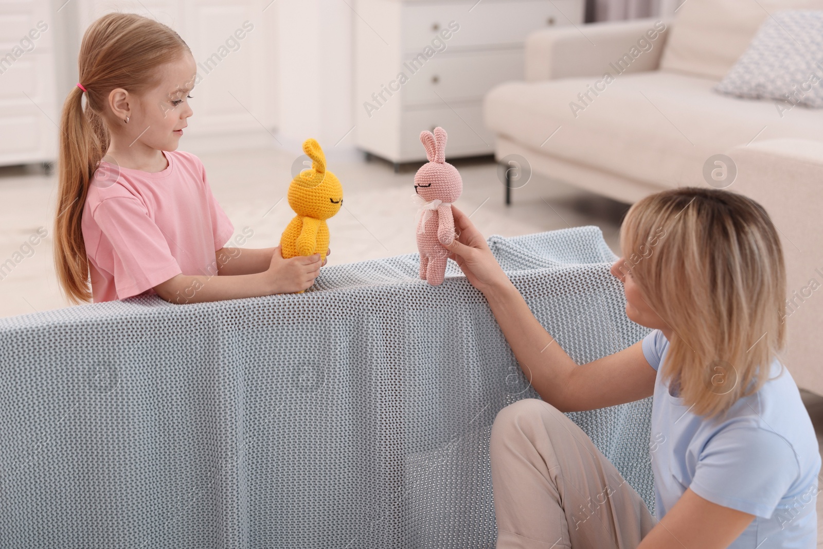 Photo of Puppet theatre. Mother and daughter performing show at home