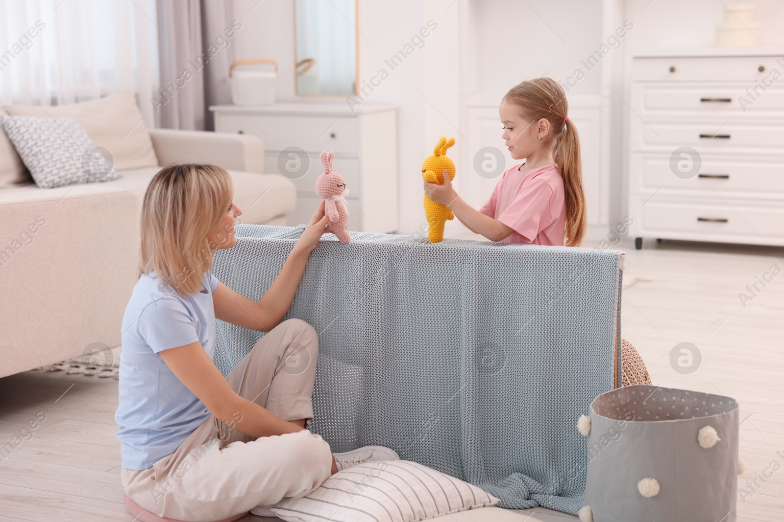 Photo of Puppet theatre. Mother and daughter performing show at home