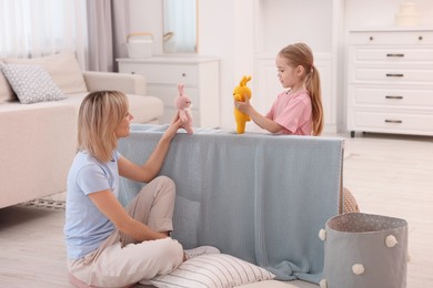 Puppet theatre. Mother and daughter performing show at home