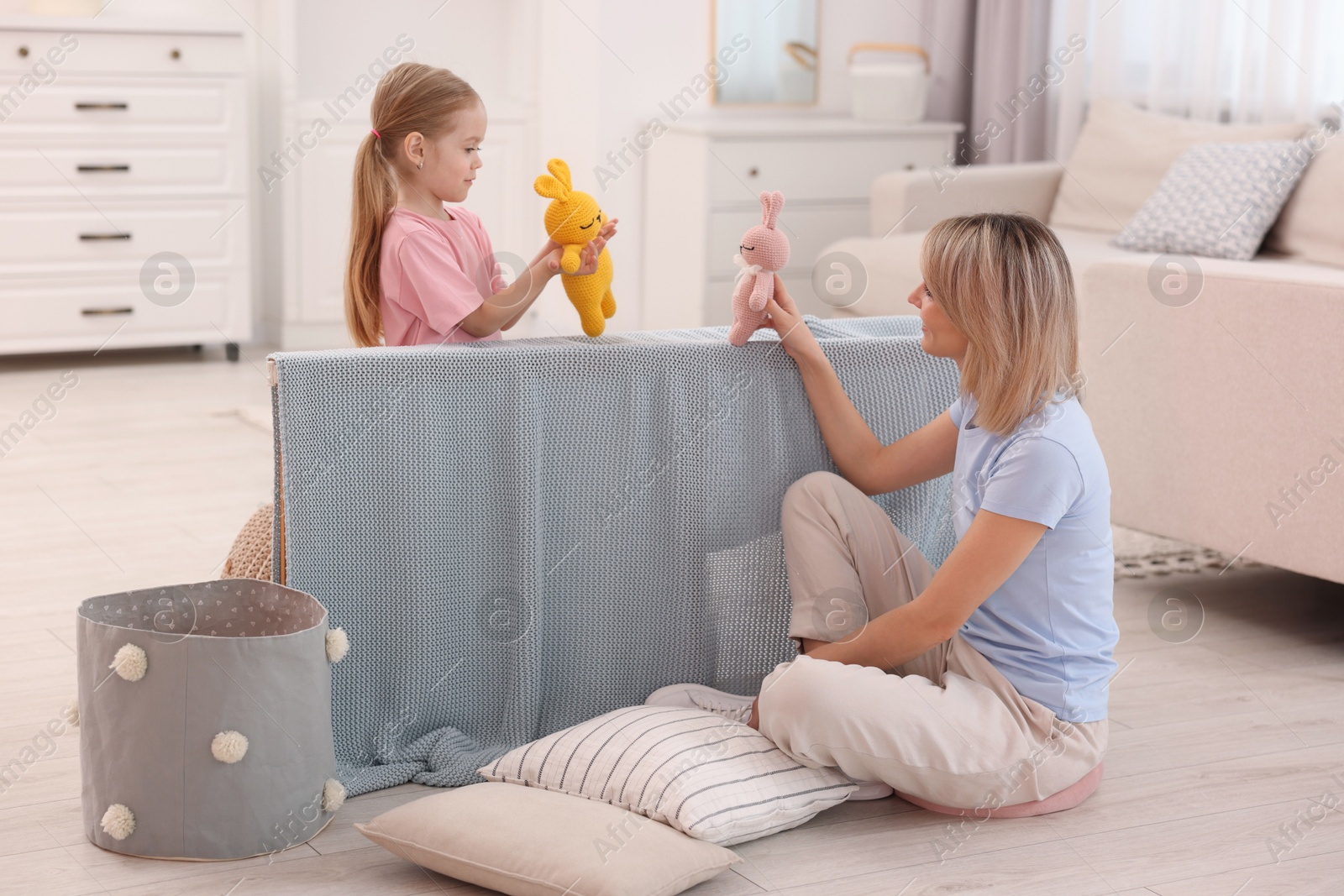 Photo of Puppet theatre. Mother and daughter performing show at home