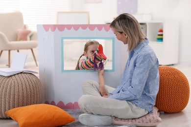 Photo of Puppet theatre. Girl performing show to her mother at home