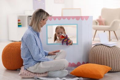 Puppet theatre. Girl performing show to her mother at home