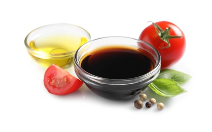 Delicious balsamic vinegar, olive oil, basil, tomatoes and peppercorns isolated on white