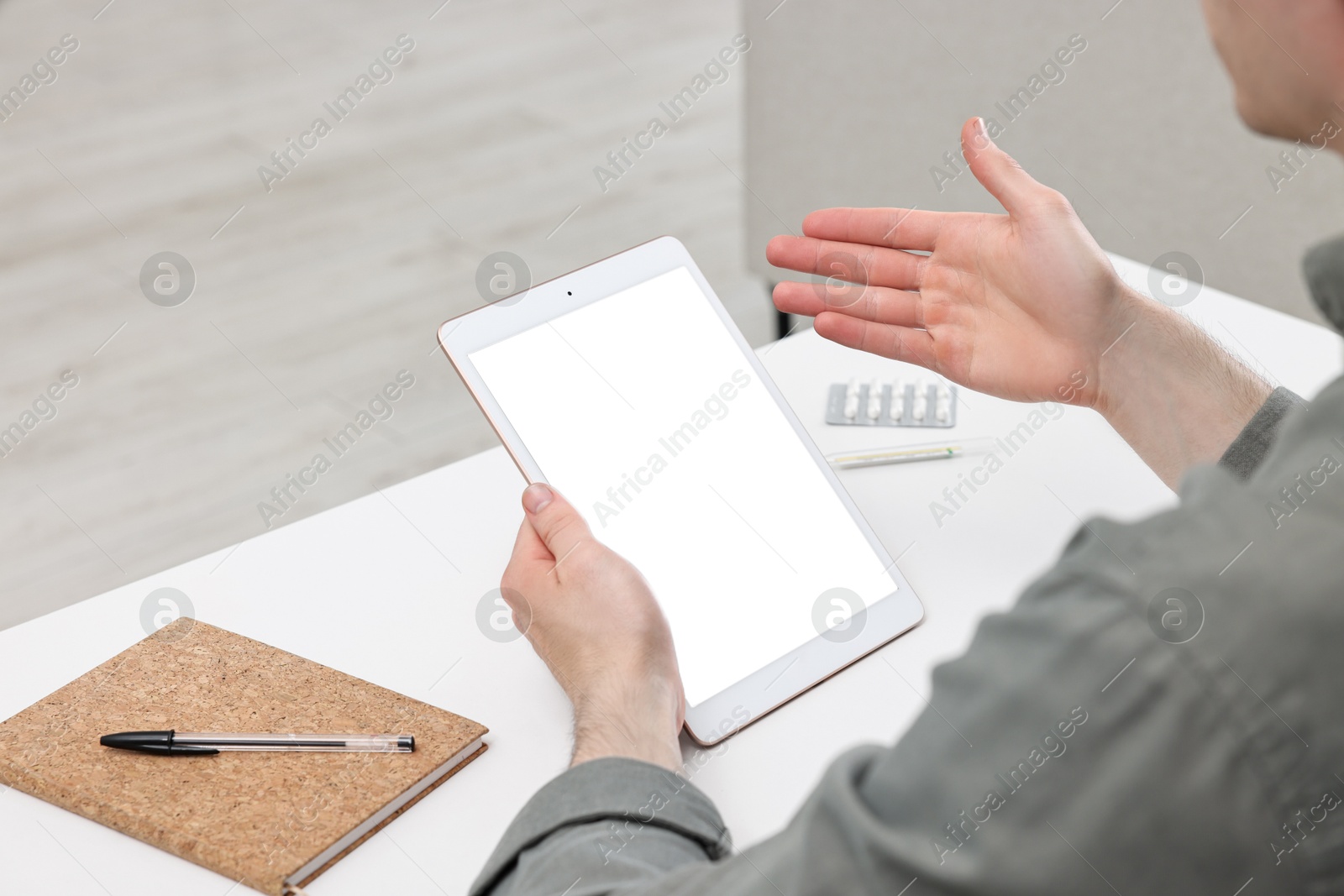 Photo of Sick man having online consultation with doctor via tablet at home, closeup