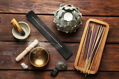 Photo of Flat lay composition with incense sticks on wooden table. Om ligature