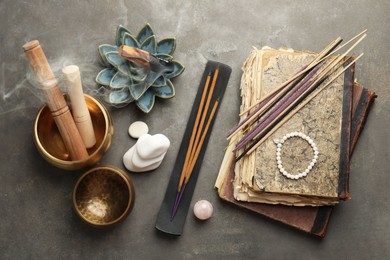 Flat lay composition with incense sticks on gray textured table. Om ligature