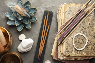 Photo of Flat lay composition with incense sticks on gray textured table. Om ligature