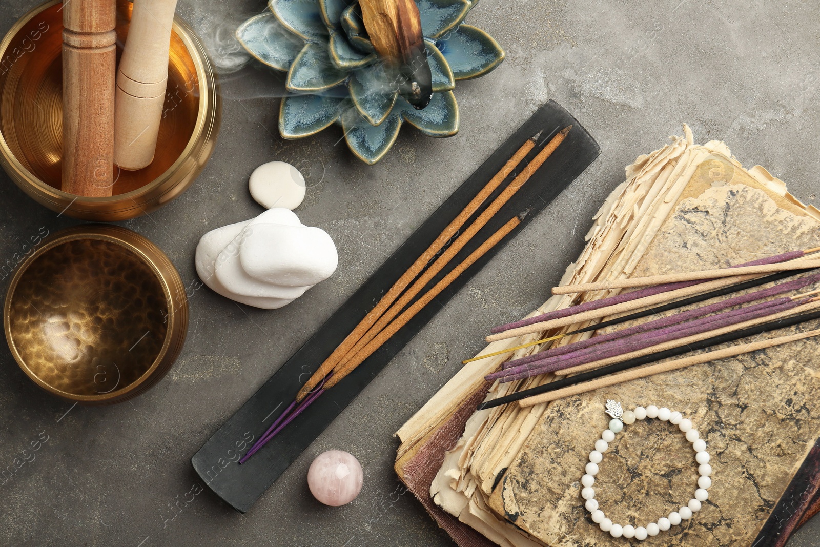 Photo of Flat lay composition with incense sticks on gray textured table. Om ligature