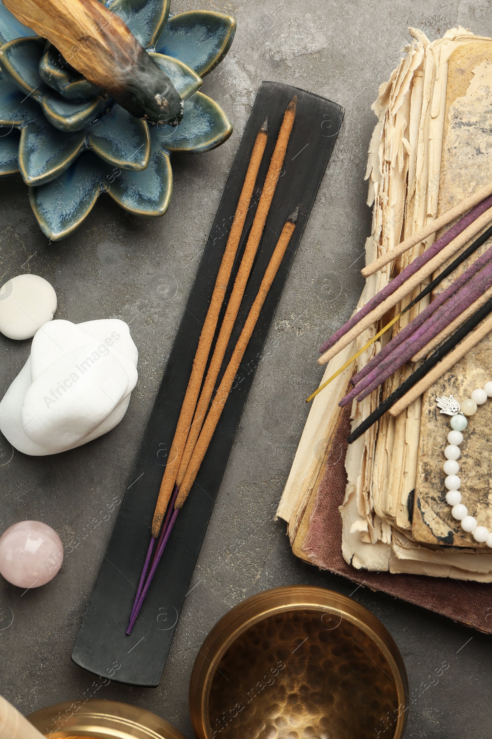 Photo of Flat lay composition with incense sticks on gray textured table. Om ligature