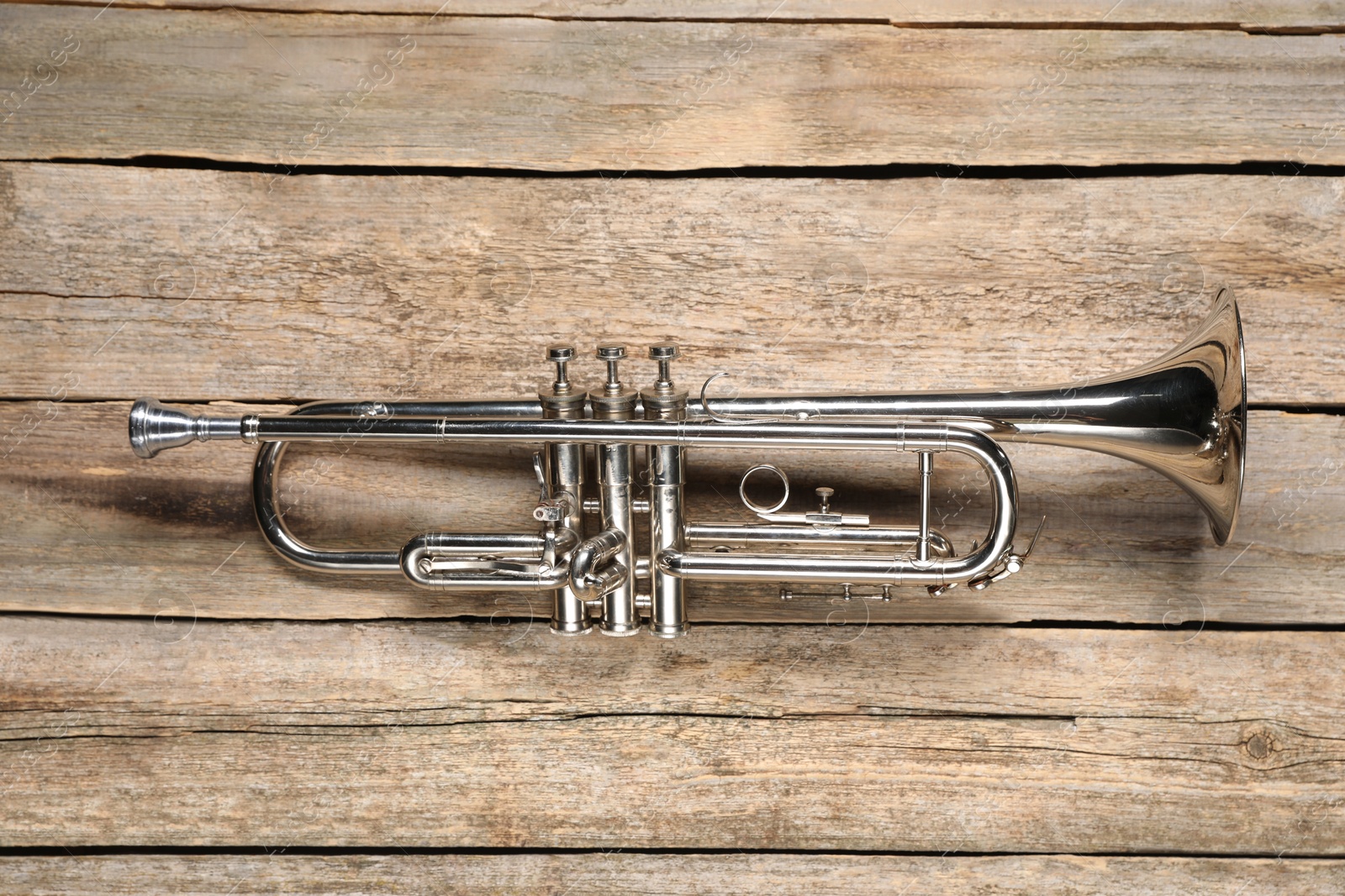 Photo of One trumpet on wooden table, top view