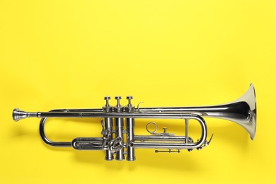 Photo of One trumpet on yellow background, top view. Space for text