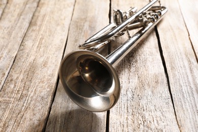 Photo of One trumpet on wooden table, closeup. Musical instrument