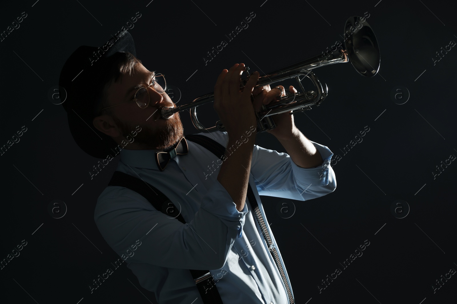 Photo of Professional musician playing trumpet on black background