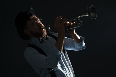 Photo of Professional musician playing trumpet on black background