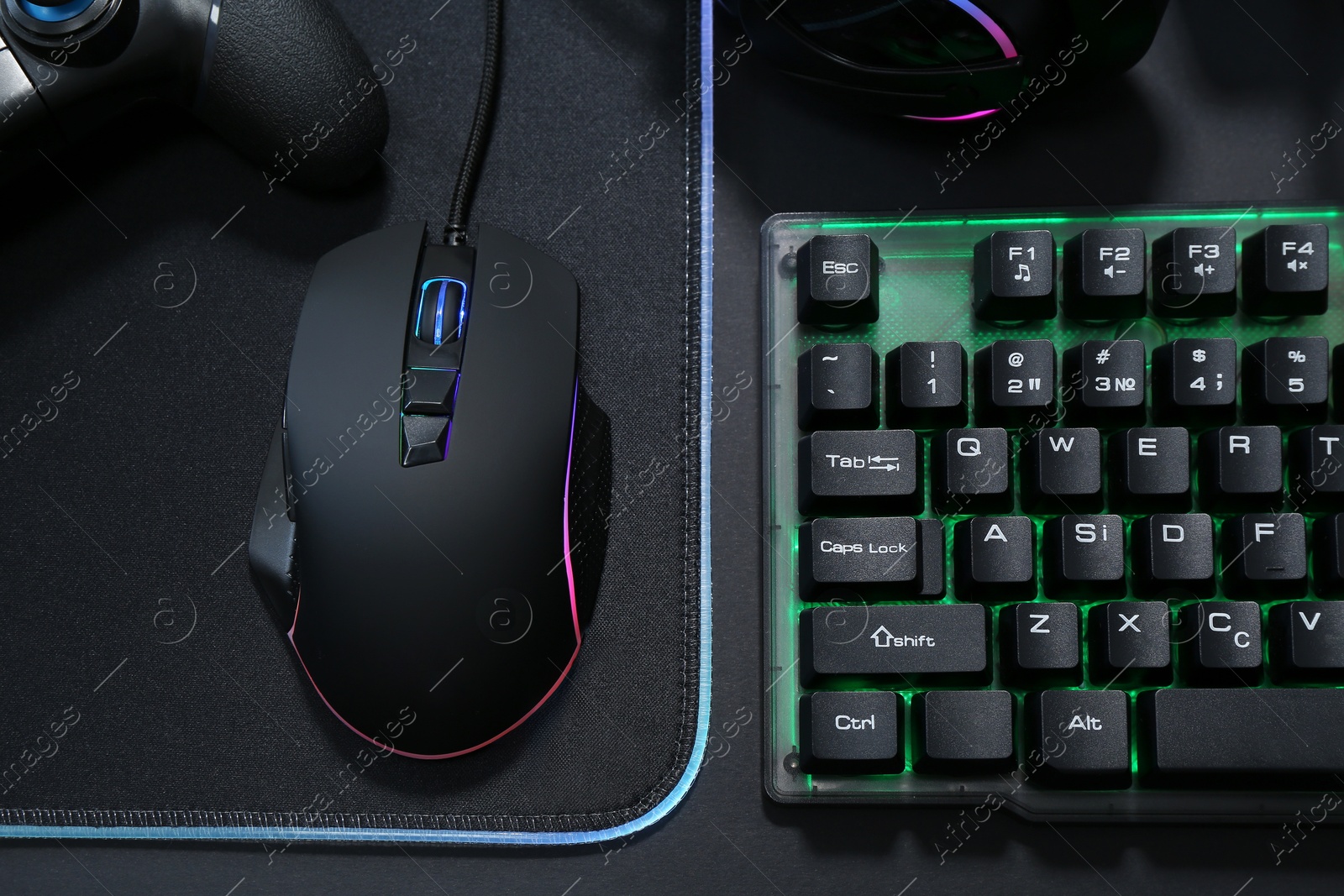 Photo of Computer mouse, RGB keyboard and game controller on black background, top view