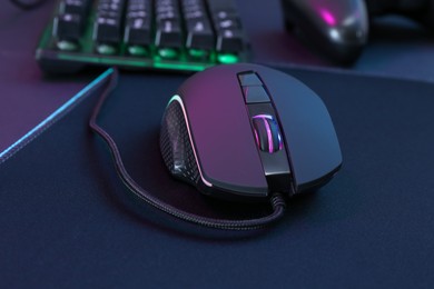 Photo of Computer mouse and mousepad on table, closeup