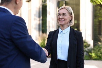 International relations. Diplomats shaking hands during meeting outdoors