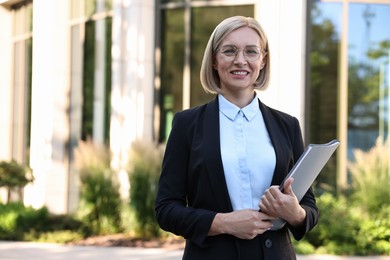 Photo of International relations. Diplomat with clipboard outdoors, space for text