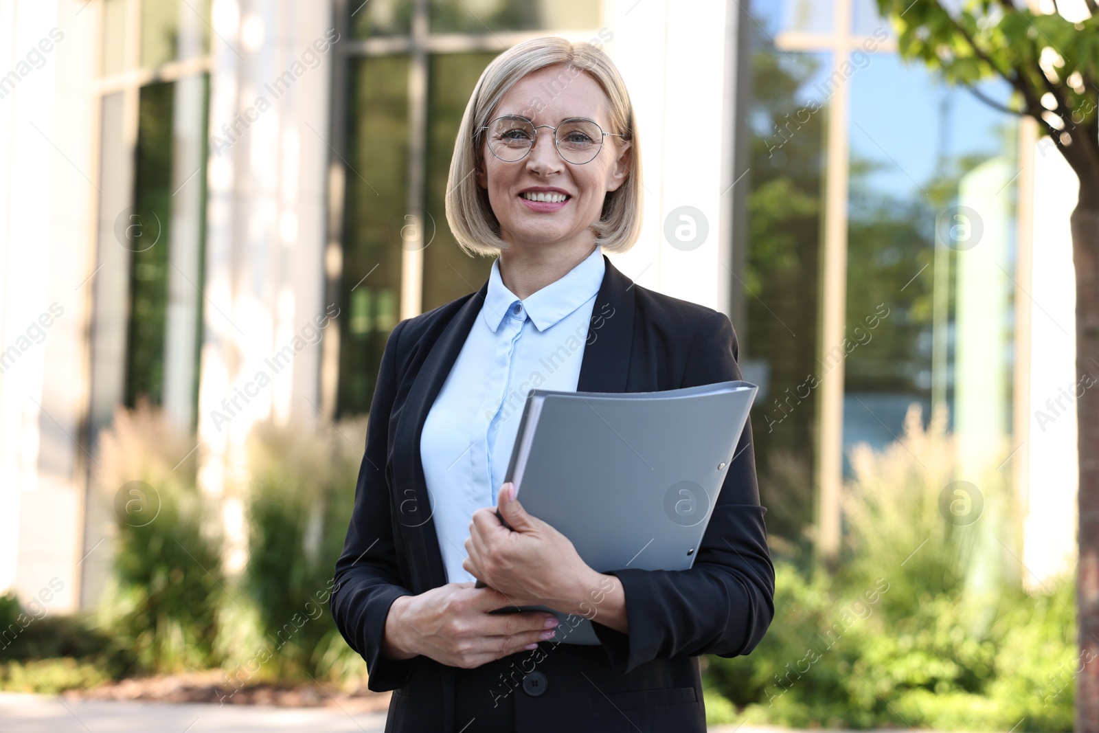 Photo of International relations. Diplomat with clipboard in suit outdoors