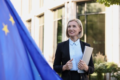 International relations. Diplomat with clipboard near flag of European Union outdoors