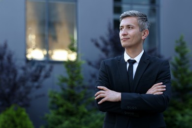 Photo of International relations. Diplomat with crossed arms in suit outdoors, space for text