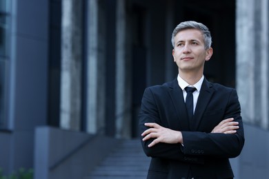 Photo of International relations. Diplomat with crossed arms in suit outdoors, space for text