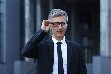 Photo of International relations. Diplomat with glasses in suit outdoors