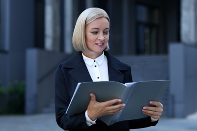 Photo of International relations. Diplomat with clipboard in suit outdoors