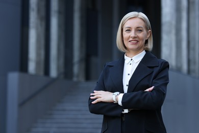 International relations. Diplomat with crossed arms in suit outdoors, space for text