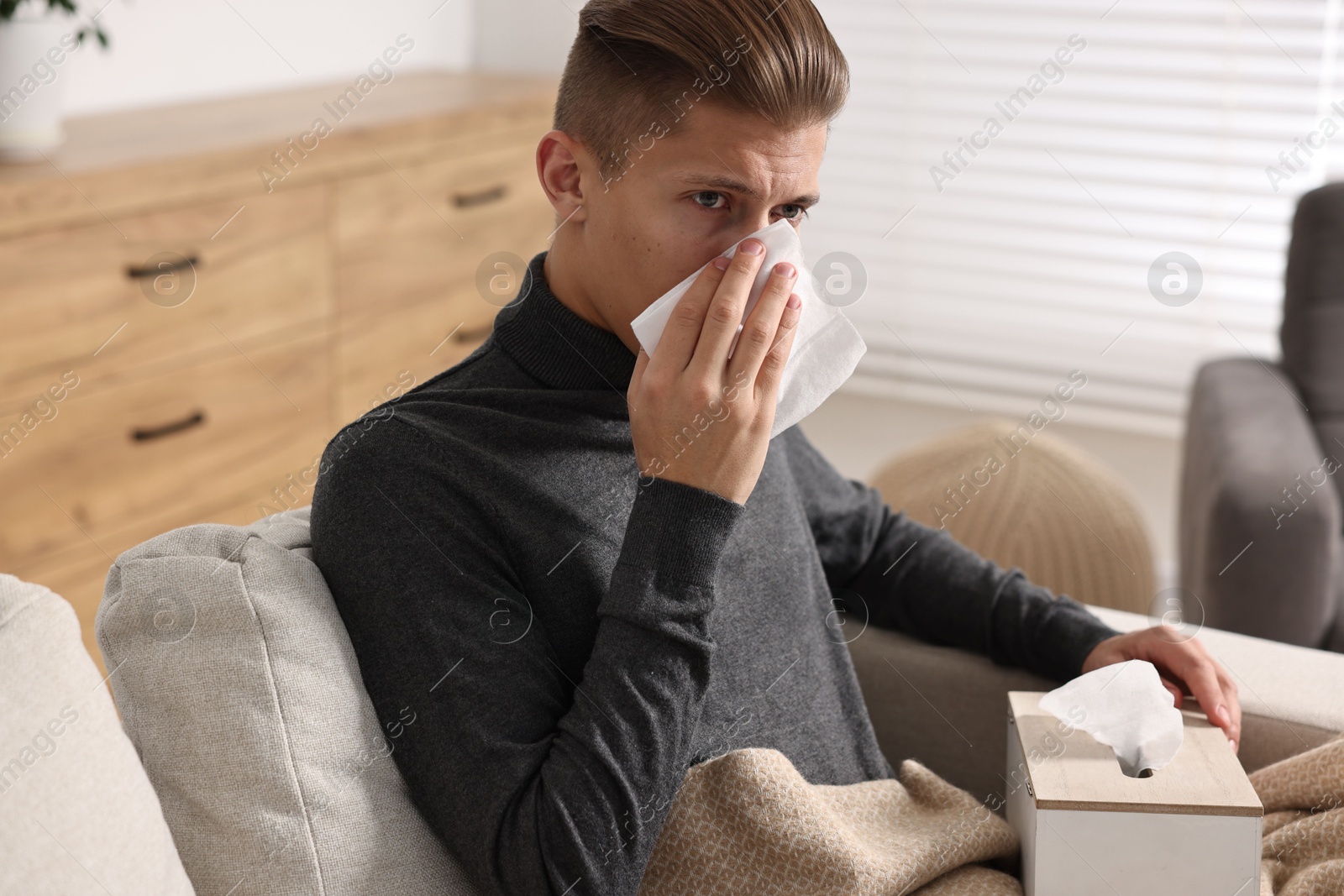 Photo of Young man with tissue suffering from sinusitis at home