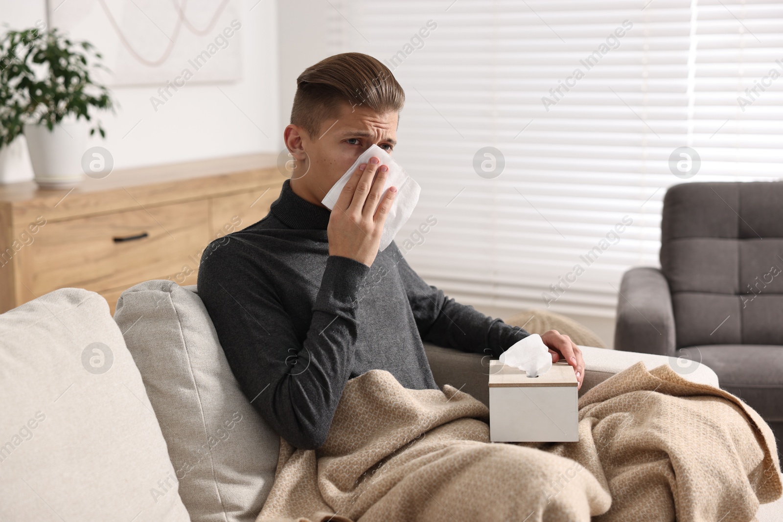 Photo of Young man with tissue suffering from sinusitis at home