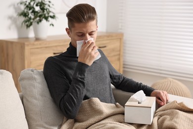 Young man with tissue suffering from sinusitis at home