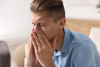 Photo of Young man suffering from sinusitis at home