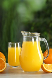 Photo of Tasty orange juice and fresh fruits on white wooden table outdoors