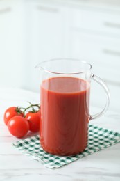 Photo of Tasty tomato juice in jug and vegetables on white marble table