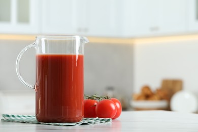 Photo of Tasty tomato juice in jug and vegetables on white marble table. Space for text