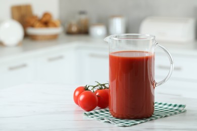 Photo of Tasty tomato juice in jug and vegetables on white marble table. Space for text