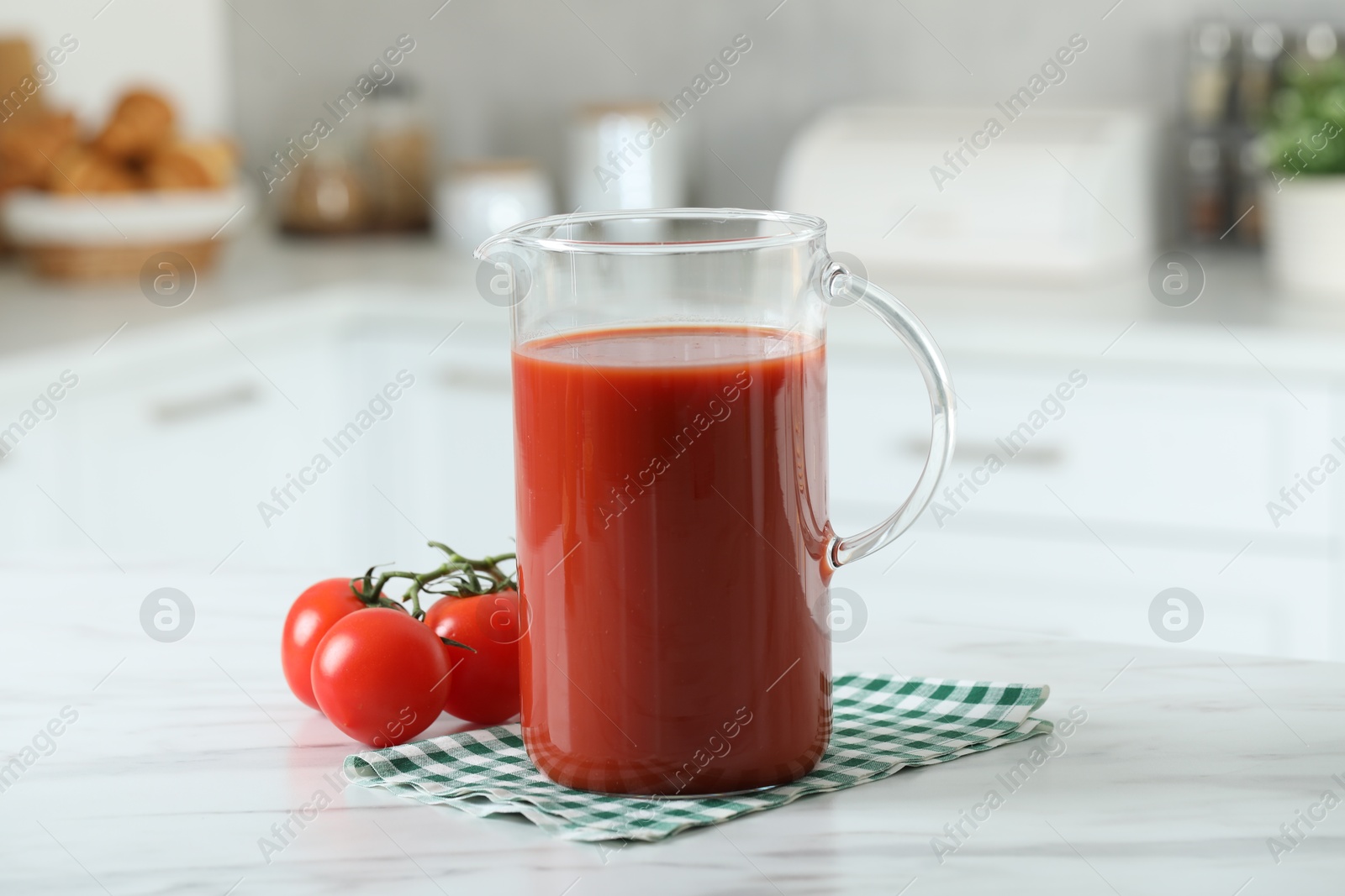 Photo of Tasty tomato juice in jug and vegetables on white marble table