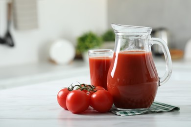 Photo of Tasty tomato juice in jug, glass and vegetables on white marble table. Space for text