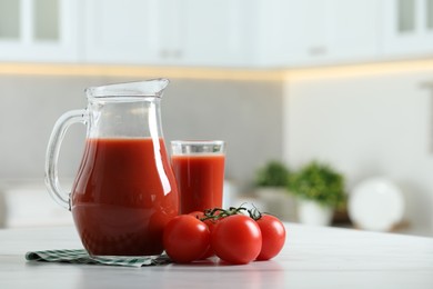 Photo of Tasty tomato juice in jug, glass and vegetables on white marble table. Space for text