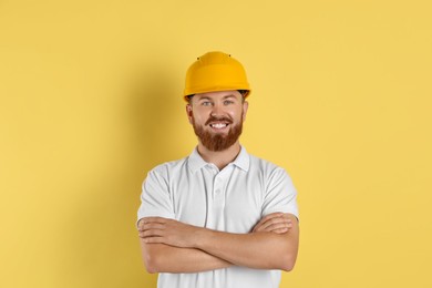 Photo of Engineer in hard hat on yellow background